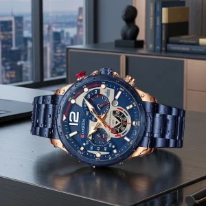 Aquí tienes una descripción estructurada y optimizada para la ficha de producto de tu tienda online, junto con un paquete de etiquetas (hashtags/keywords) para tus publicaciones y SEO.🕒 Reloj Curren 8395 Acero Hombre – Elegancia, Estilo y PrecisiónEleva tu estilo diario con el Reloj Curren 8395 para hombre, una pieza que combina un diseño sofisticado con la solidez del acero inoxidable. Diseñado para el hombre moderno, este modelo destaca por sus refinados acabados en azul y tonos oro rosa/metálicos, logrando la combinación perfecta entre un look ejecutivo y deportivo de alta gama. 🌟 Características PrincipalesDiseño Impactante: Esfera con textura detallada y subdiales multifunción que resaltan la precisión visual y la elegancia técnica. Construcción en Acero Inoxidable: Correa y caja elaboradas en aleación y acero inoxidable de alta resistencia, garantizando durabilidad y un ajuste firme en la muñeca. Dial Multifuncional: Incluye indicadores de fecha/día y sub-esferas con detalles lunares y de tiempo, aportando funcionalidad sin perder estética. Versatilidad de Us